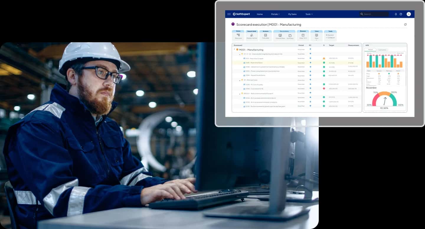Factory worker reviewing manufacturing performance metrics on a computer with a digital scorecard dashboard showing KPIs and operational indicators.